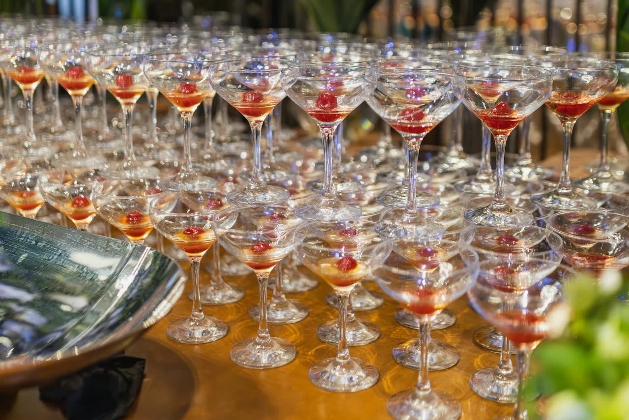 Rows of cocktail glasses arranged for guests at a wedding cocktail hour